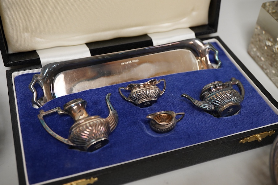 Small silver including a pair of George V pierced silver bonbon dishes, Birmingham, 1915, diameter 97mm, an Edwardian silver mounted glass inkwell, a cased modern silver miniature four piece tea set and tray and a German